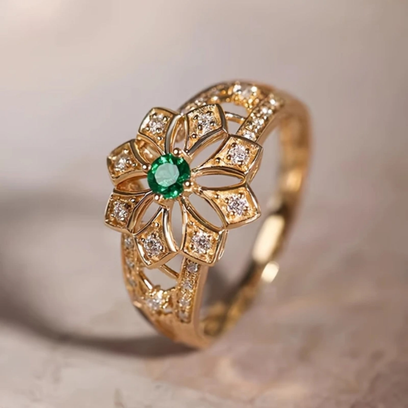 Hohlring aus Gold mit Blume und grünem Stein