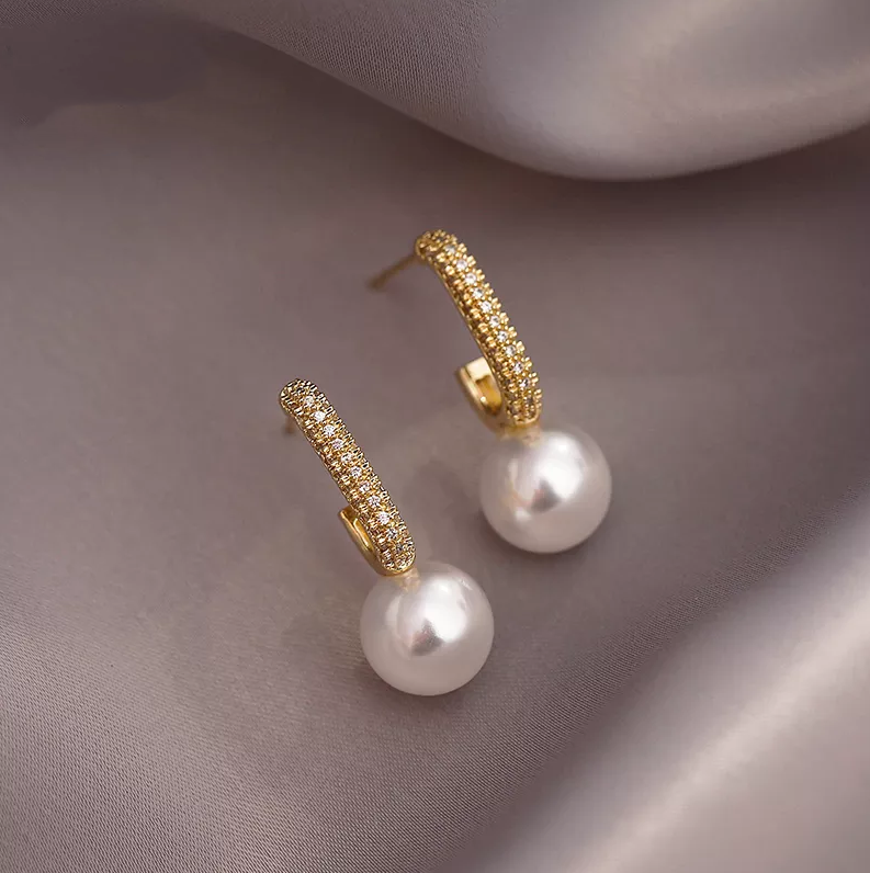 Ohrringe aus zartem Gold mit funkelnden Elementen und Perle