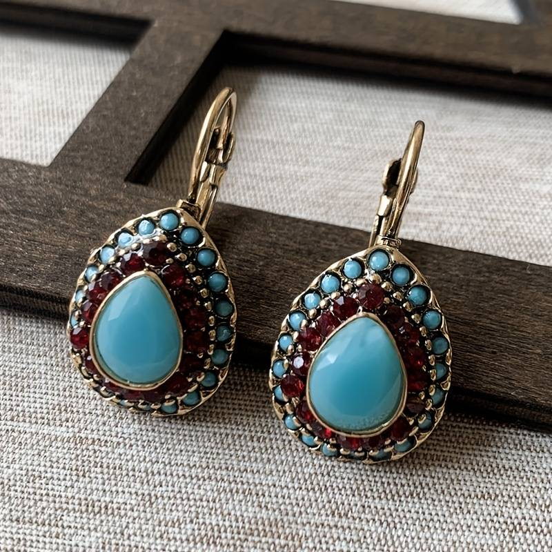 Goldene Ohrringe mit blauer Opalträne